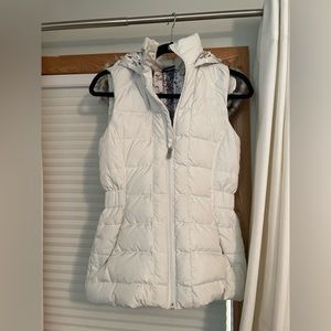 The North Face white vest with hood, detailed forest inside, cinched waist.